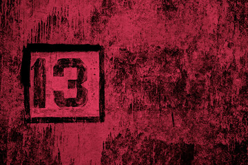 number 13 painted with black stencil on dirty red concrete wall, Baker's dozen concept