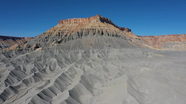 Factory Butte Of Steel Grey Mudstone Rocks In Canyon Valley Aerial Bottom Up