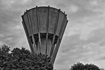 A black and white image of a water tower in Wiltshire, England reaching to the clouds.