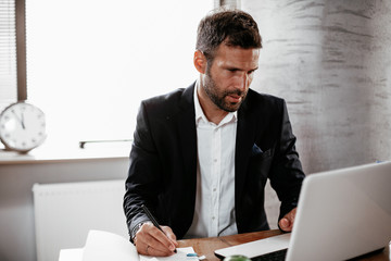 Young businessman in office. Businessman sitting at office desk working on laptop computer
