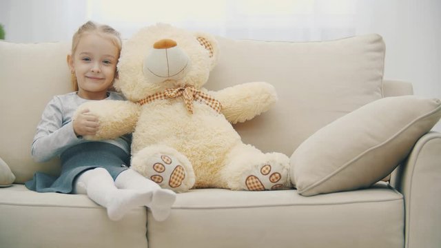 4k slowmotion video of little girl sitting on the sofa and posing.