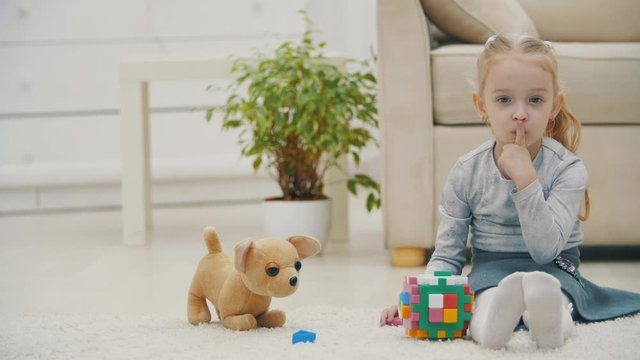 Girl appears in the frame and show silent sign at yellow background slow motion.