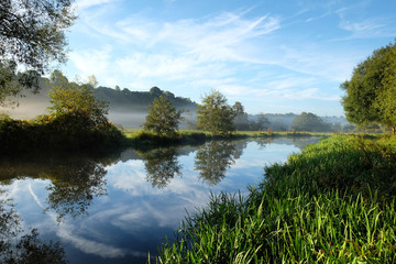 Early morning mist over the meadows on the River Wey in Godalming, Surrey, on a cold autumn morning.