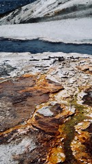 Abstract Dark Blue Natural Spring River with White, Brown, and Orange Rocky Edge