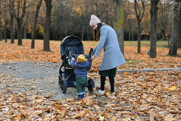 child helps mom push the stroller