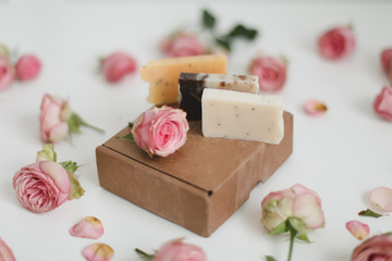 Gift box with natural homemade soap bars and rose flowers on white background. Holiday gift,...