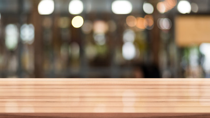Empty wooden table with blurred cafe and coffee shop interior background