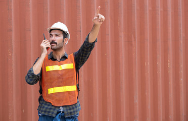 Engineer worker or technical standing in the container yard shipping area and used radio...