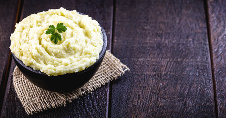 potato puree or cream served in handmade clay pot, on a rustic background on wooden table. Organic...