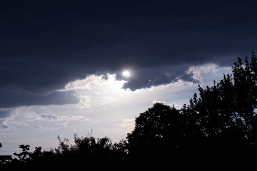 The sun runs away from thunderclouds.