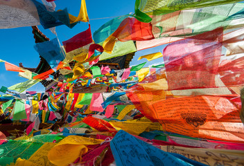 Fototapeta na wymiar Colorful Tibetan Buddhist prayer flags hanging from a pagoda near Kawa Garpo mountains, home of one of Tibetan Buddhism's most sacred pilgrimages. 