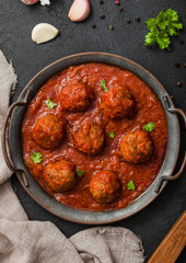 Traditional spicy meatballs in tomato sauce with pepper, garlic and parsley