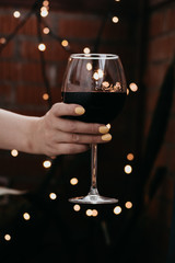  Glass of red wine in hand, beautiful bokeh on background