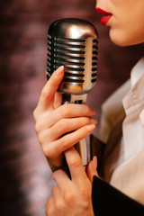 Singer lips and retro microphone. Girl on stage holding a microphone close up. Sensual performance...
