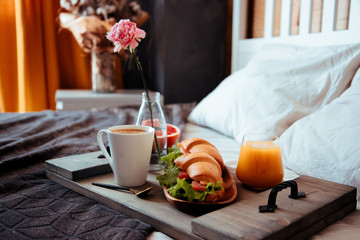  Breakfast in bed on a wooden tray - sandwiches, coffee and orange juice
