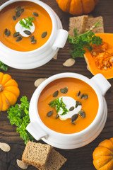 Pumpkin soup with parsley and cream in the bowl