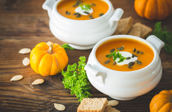 Pumpkin soup with parsley and cream in the bowl