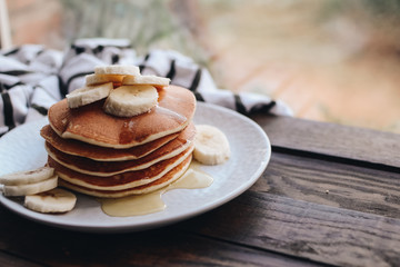 Delicious pancakes topped with banana and honey. Homemade classic american pancakes. Breakfast in the morning. 
