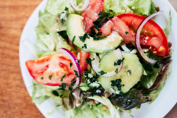 Salade verte avec tomates avocats et oignons rouge - Plat frais et sain	