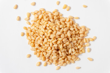 Peeled Pine Nuts. Unshelled kernels. A bunch of nuts lies on a white background.