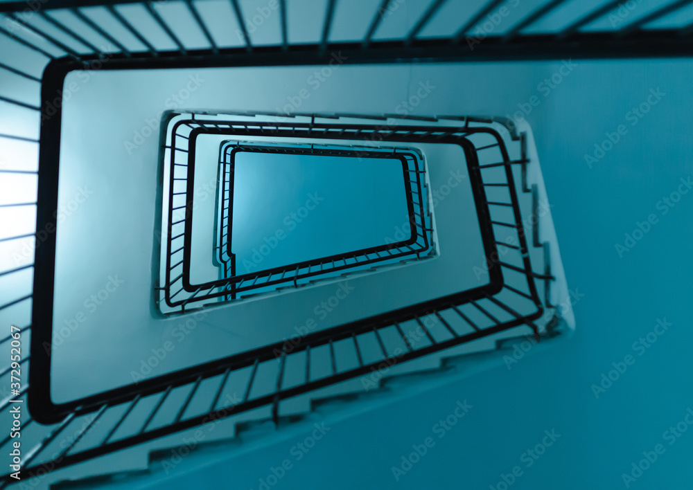 Poster perspective shot from below a stairwell creating geometric pattern