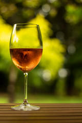 Large crystal glass with cold rosé wine inside. High class drink concept. Alcoholic drink on a table in a package.