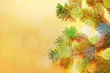 Fototapeta na wymiar Green spruce branch close up on yellow background with multicolored bokeh. Christmas or New Year festive background. Greeting card or invitation with copy space for text.