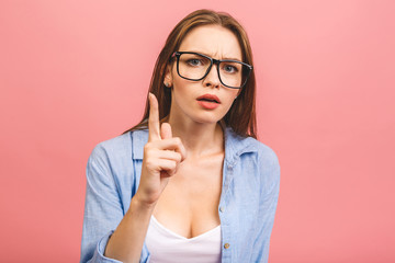 Young brunette woman throwing a finger as aggresion concept isolated over pink background with text...