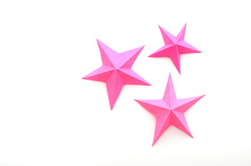 Fototapeta premium Pink origami folding paper stars on white