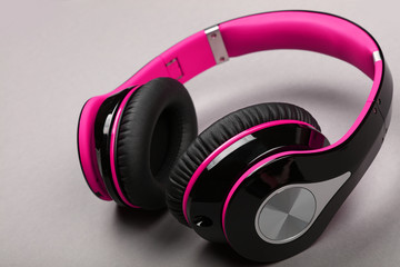 Close up modern pink headphones on gray table