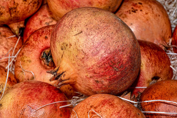 pomegranate raw fruits with straw. close-up 