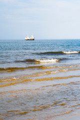 The concept of travel and rest at the seaside, sea waves on the background of the shoreline and sunset
