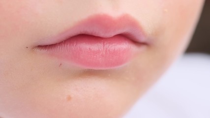 Closeup view of cute pink lips of young caucasian child. Macro.