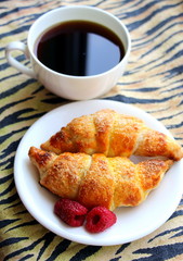 Fresh baked croissants with coffee for breakfast at home.