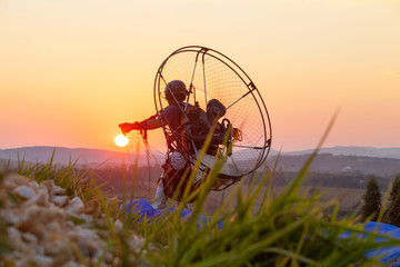 man with paramotor preparing to launch at sunset