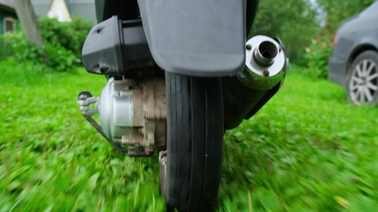 Male traveller is driving moped, close up