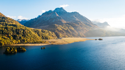 Yellow larches and alpine lake in fall, Swiss alps