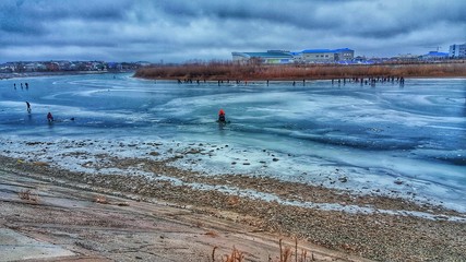 Frozen river, with fishermen fishing below the ice
