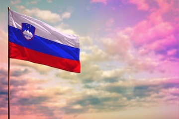 Fluttering Slovenia flag mockup with the space for your content on colorful cloudy sky background.