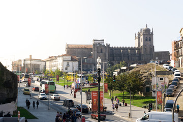 Busy street with cars and people with the cathedral in the background