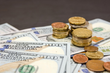 Stacks of coins and dollars on a black background. Financial concept.