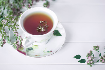 herbal tea in a Cup on a white background. oregano tea in a Cup close-up. tea and oregano flowers.