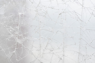 White cracked glass texture background. Texture broken glass window with cracks. Broken screen.