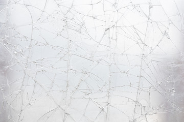 White cracked glass texture background. Texture broken glass window with cracks. Broken screen.