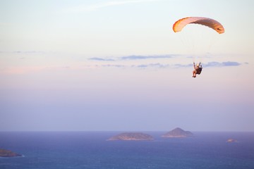 extreme paraglider over Brazilian beach at sunset