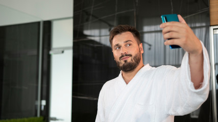 Naklejka na ściany i meble guy takes a selfie in a bathrobe