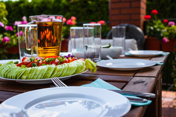 A table set in the garden. Food, cutlery and plates waiting for guests
