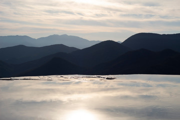 Amanecer azul con montañas y agua cristalina