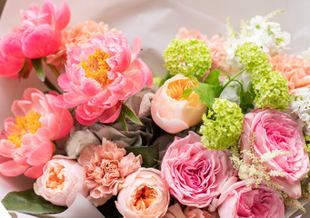 Flower shop. Beautiful bouquet of mixed flowers in man hands. The work of the florist at a flower shop. Delicate bright color. Fresh cut flower.
