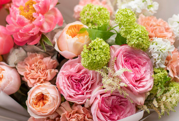 Flower shop. Beautiful bouquet of mixed flowers in man hands. The work of the florist at a flower shop. Delicate bright color. Fresh cut flower.